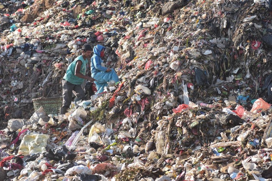 BEKASI, WEST JAVA, INDONESIA - 2019/09/11: Scavengers sort and collect plastics for recycling at the garbage mountain in Bantar Gebang landfill that is considered to be the worlds largest dump. 
Jakar ...
