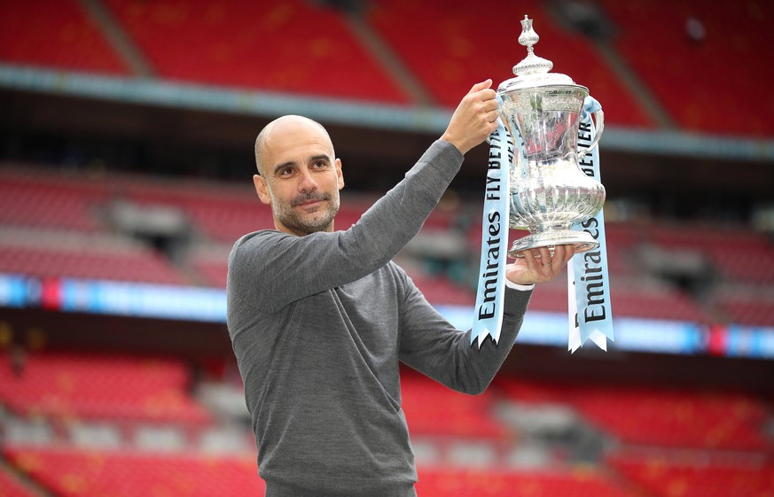 Manchester City win the 2020/21 Premier League Package File photo dated 18-05-2019 of Manchester City manager Pep Guardiola celebrates with the trophy after winning the FA Cup Final at Wembley Stadium ...
