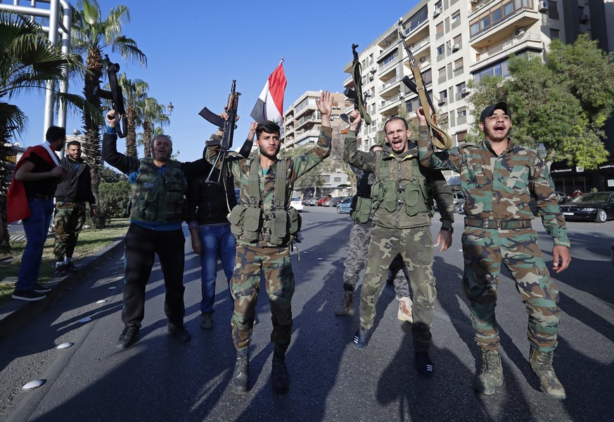 Syrian soldiers hold their weapons as they dance and chant slogans against U.S. President Trump during demonstrations following a wave of U.S., British and French military strikes to punish President  ...
