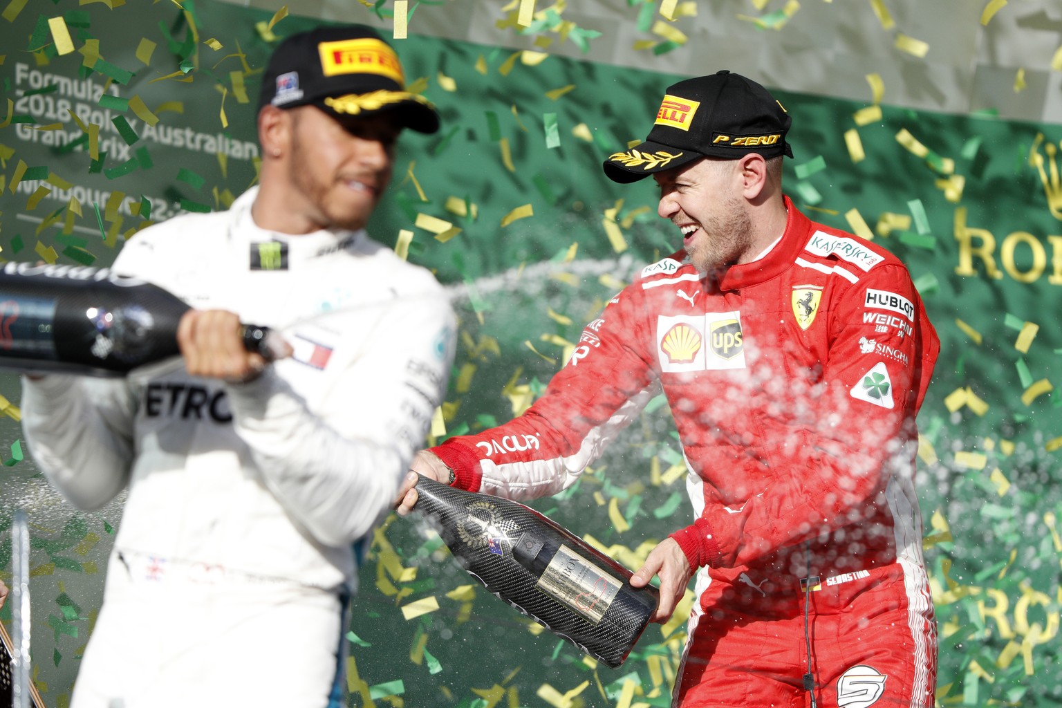 Ferrari driver Sebastian Vettel, right, of Germany and Mercedes driver Lewis Hamilton of Britain spray champagne after the first race of the season at the Australian Formula One Grand Prix in Melbourn ...