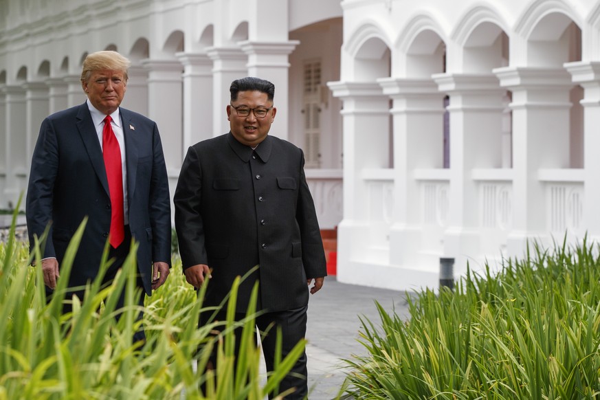 U.S. President Donald Trump walks with North Korea leader Kim Jong Un after lunch at the Capella resort on Sentosa Island Tuesday, June 12, 2018 in Singapore. (AP Photo/Evan Vucci)