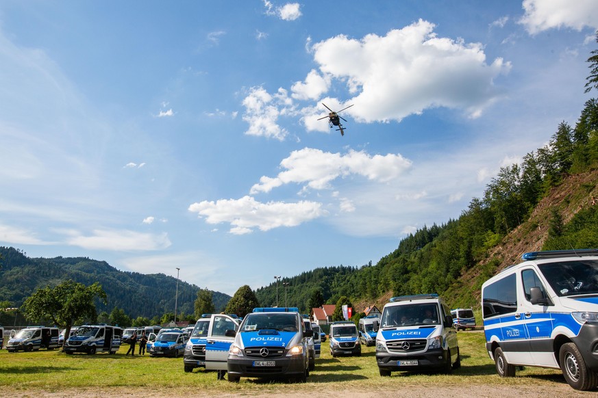 dpatopbilder - 13.07.2020, Baden-Württemberg, Oppenau: Ein Hubschrauber der Polizei fliegt nahe der Gemeinde Oppenau über einen Sportplatz, auf dem Polizeifahrzeuge stehen und der als Sammelpunkt der  ...