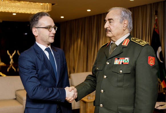 German Foreign Minister Heiko Maas shakes hands with Libya&#039;s commander Khalifa Haftar, in Benghazi, Libya, January 16, 2020, in this handout photo provided by the German Foreign Ministry. Auswaer ...