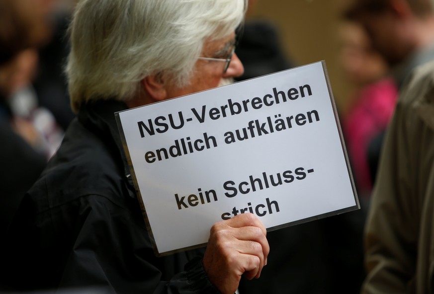 A person holds a placard reading &quot;finally solve NSU crimes - dont mark it finished&quot; in front of a Munich court before judges give their verdict in the trial of suspected NSU neo-Nazi gang me ...