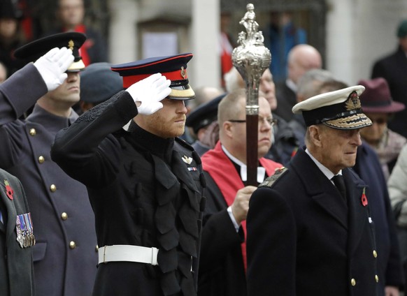 ARCHIV - 10.11.2016, Gro�britannien, London: Der britische Prinz Harry salutiert, w�hrend er und Prinz Philip in Uniform an der offiziellen Er�ffnung der j�hrlichen Veranstaltung Field of Remembrance  ...