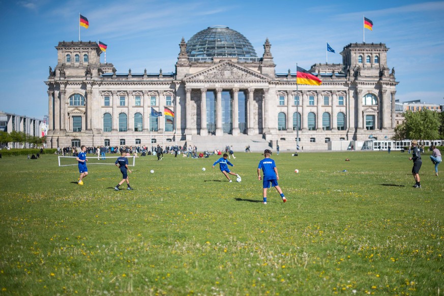 Berlin Fruehlingswetter Platz der Republik Jugendliche geniessen das gute Wetter auf der Wiese vor dem Reichstagsgebaeude Platz der Republik und trainieren Fussball. 6.5.2020, Berlin *** Berlin Spring ...