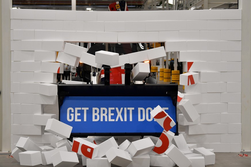 Britain&#039;s Prime Minister Boris Johnson drives a JCB machine through a symbolic wall with the Conservative Party slogan &#039;Get Brexit Done&#039; in the digger bucket, during an election campaig ...