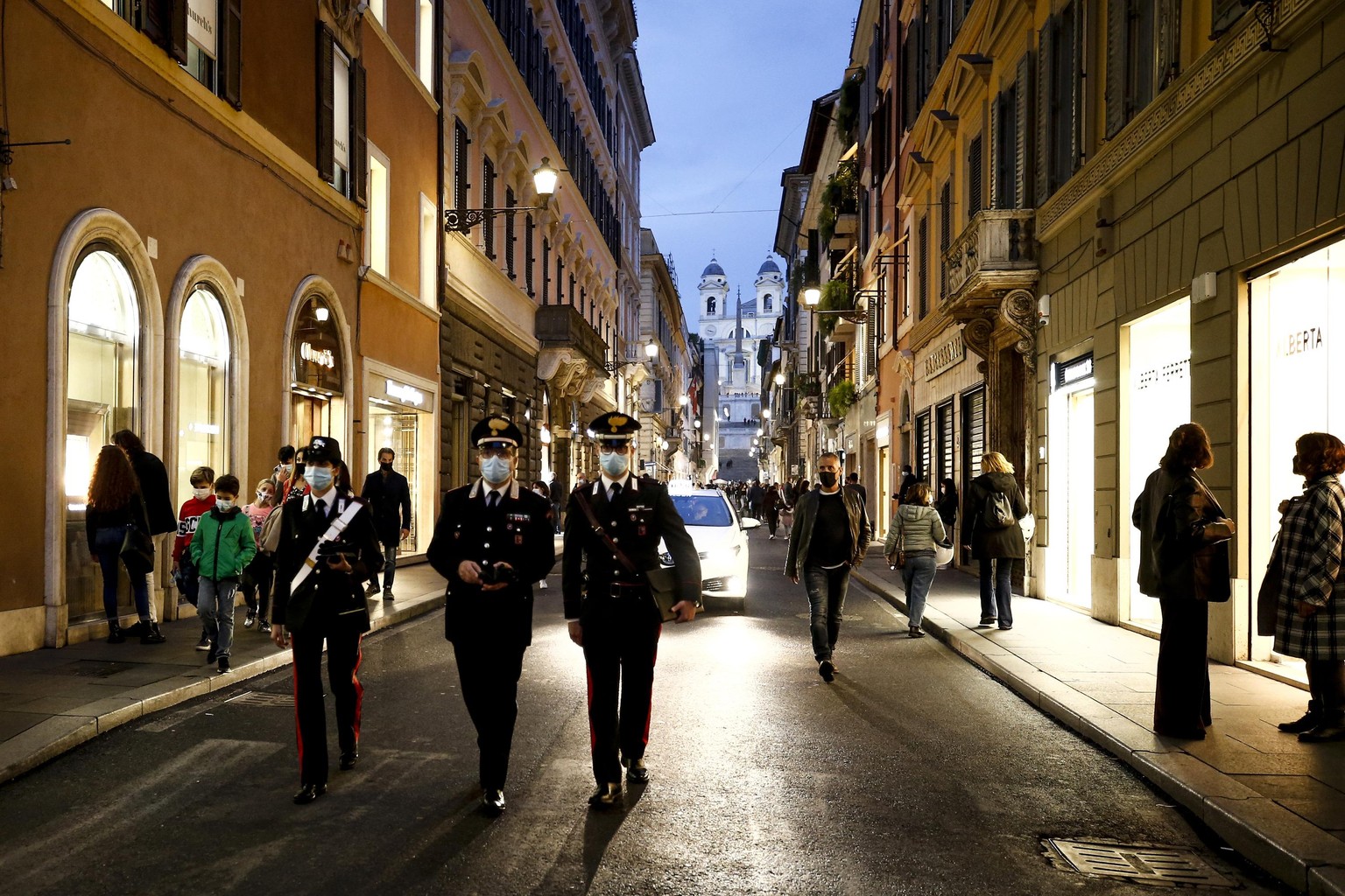 14.11.2020, Italien, Rom: Polizeibeamte gehen in der Einkaufsstraße Via dei Condotti. In Rom werden vorübergehend Polizeikontrollen in der beliebten Einkaufszone durchgeführt, um zur Eindämmung der Co ...