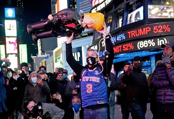 04.11.2020, USA, New York City: Ein Demonstrant h�lt eine Trump-Puppe am Times Square hoch. Foto: Seth Wenig/AP/dpa +++ dpa-Bildfunk +++