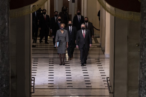 Clerk of the House Cheryl Johnson along with acting House Sergeant-at-Arms Tim Blodgett, right, and Rep. Jamie Raskin, D-Md., lead the Democratic House impeachment managers as they walk through Statua ...